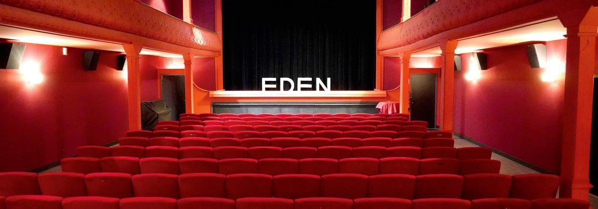 salle de cinéma avec fauteuil rouge et mur rouge, un petit étage avec balcon
