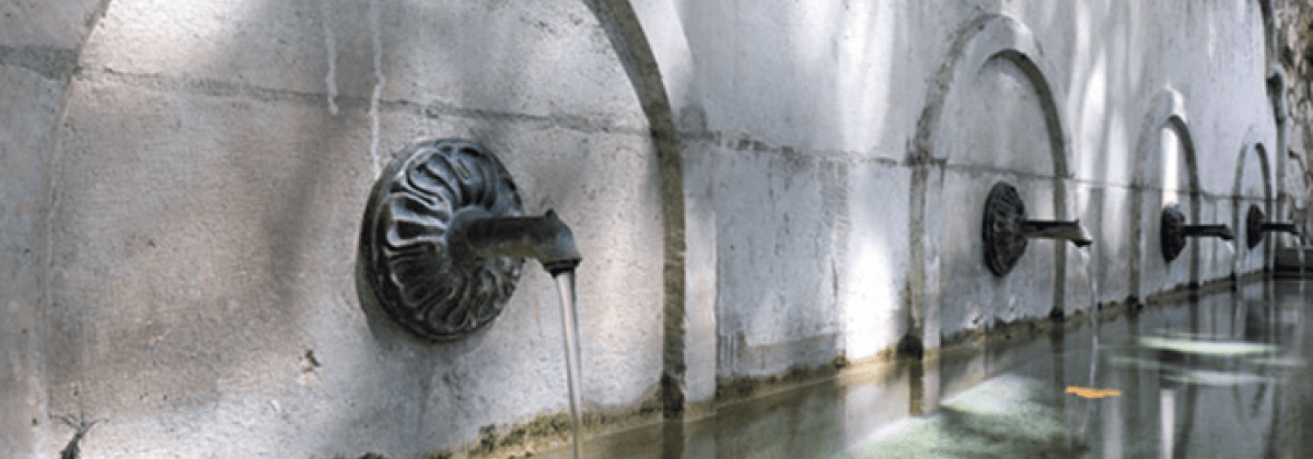 fontaine longue avec plusieurs robinet d'où s'écoule l'eau
