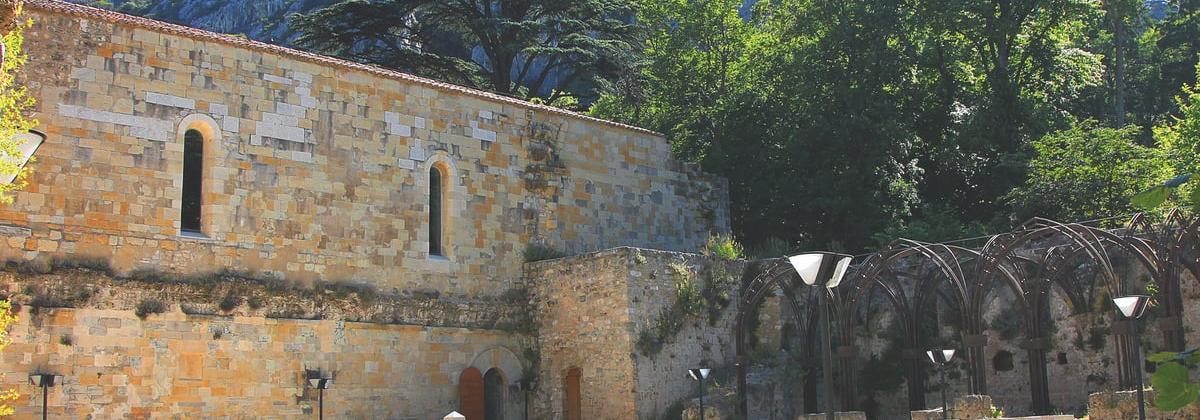 l'abbaye de côté avec un joli mur tout en brique de pierre et des alcôves de fer forgé dans le jardin