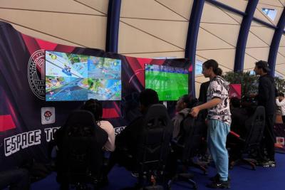 Lors du Mercredi sport et e-sport des Bouches-duRhône, plusieurs jeunes adultes jouent à Mario Kart et FIFA sur deux grands écrans dans un espace dédié au gaming. Assis dans des fauteuils de compétition, concentrés sur leurs manettes, ils sont entourés d’un décor avec l’inscription “Espace Tournoi E-sport” . L’ambiance est immersive, moderne et tournée vers le jeu vidéo compétitif. - Agrandir l'image 3 sur 5, fenêtre modale