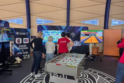 Lors du Mercredi sport et e-sport des Bouches-du-Rhône, des séniors explorent un espace dédié aux loisirs numériques. Deux grands écrans diffusent des parties de Mario Kart et de bowling. Devant, une table de baby-foot ajoute une touche physique. L’ambiance est ludique, interactive et pensée pour tous les âges. - Agrandir l'image 5 sur 5, fenêtre modale