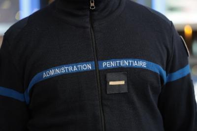 Un adulte en veste bleu marine porte une inscription “ADMINISTRATION PÉNITENTIAIRE” sur une bande horizontale bleue. Le décor intérieur est lumineux et semble accueillir plusieurs agents. L’atmosphère évoque un événement professionnel. Il s'agit decérémonie des voeux au personnel des forces de l'ordre et de secours des Bouches-du-Rhône. - Agrandir l'image 9 sur 18, fenêtre modale