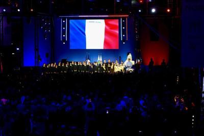 Scène présentée devant un large public avec un écran affichant le drapeau français et une chorale - Agrandir l'image 20 sur 20, fenêtre modale