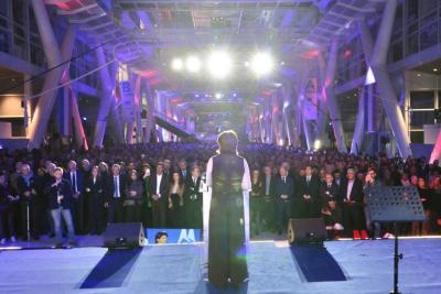 Martine Vassal vue de dos sur scène face à une foule nombreuse dans un grand hall éclairé - Agrandir l'image 18 sur 20, fenêtre modale
