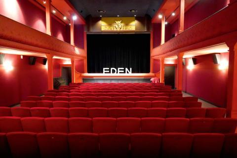 salle de cinéma avec fauteuil rouge et mur rouge, un petit étage avec balcon